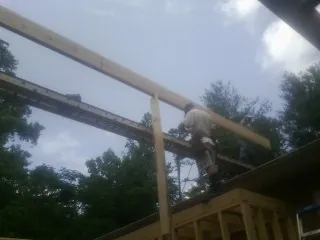 Carpenter setting a ridge beam over a new addition frame — Ice Dam Removal by Roofing Brothers in Turbotville