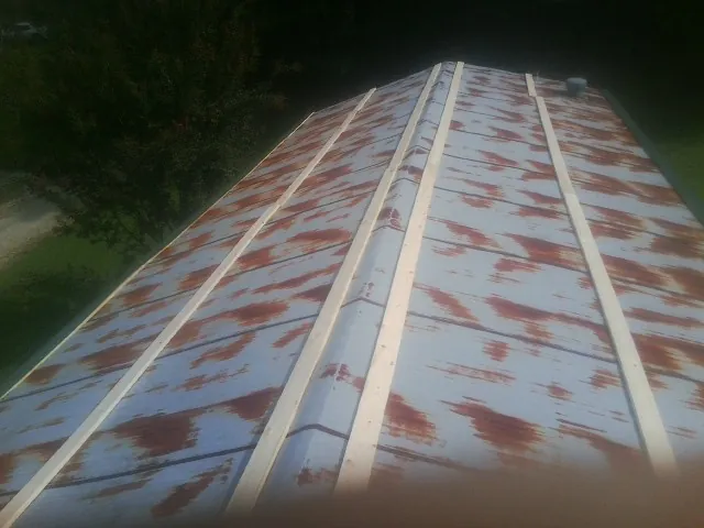 Rusted metal roof panels with new wood purlins before replacement — Storm Damage Roof Repair in Turbotville by Roofing Brothers