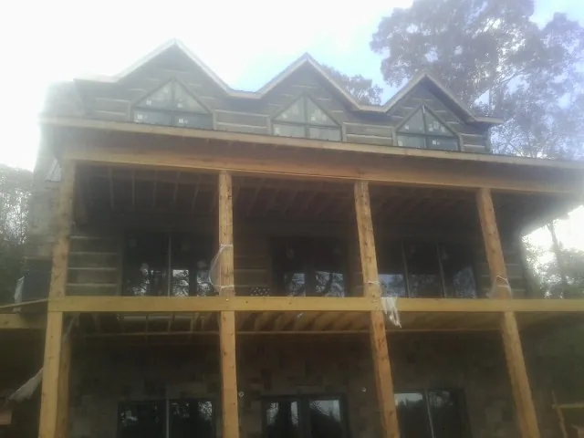 Dormers and porch framing on a large log home under construction — Roof Coating work by our crew in Turbotville