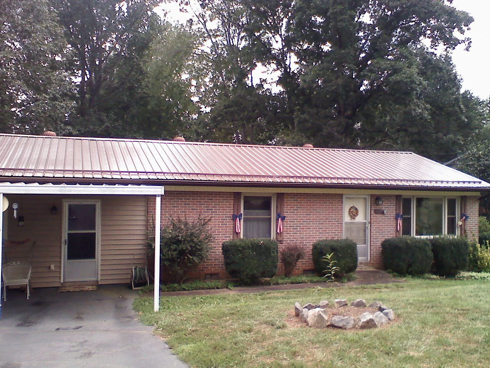 Bronze metal roof and carport on a brick ranch home — Roof Repair work by our crew in Turbotville